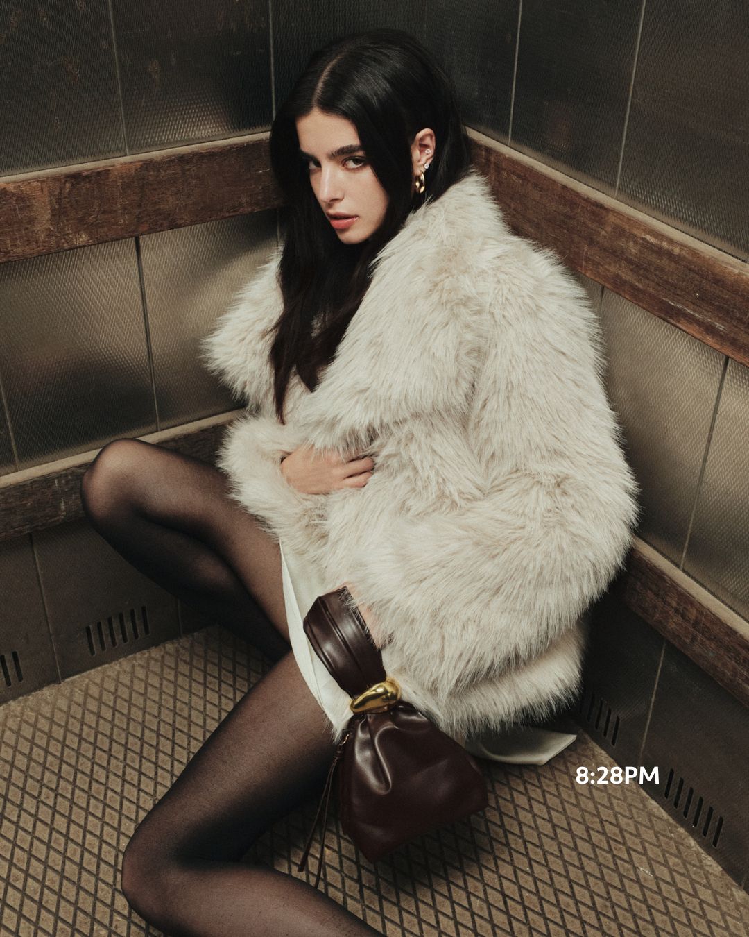 Model in a faux fur coat wearing Puffy Disc Hoops in gold