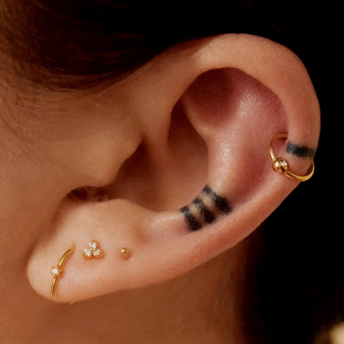 Shooting Star Open Hoops, Crystal Trinity Push Pin flat back earring and Orbital Crystal Cartilage Hoop on model (Titanium - Gold)