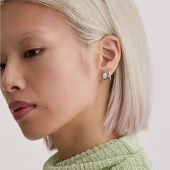 Model wearing silver MIRU earrings