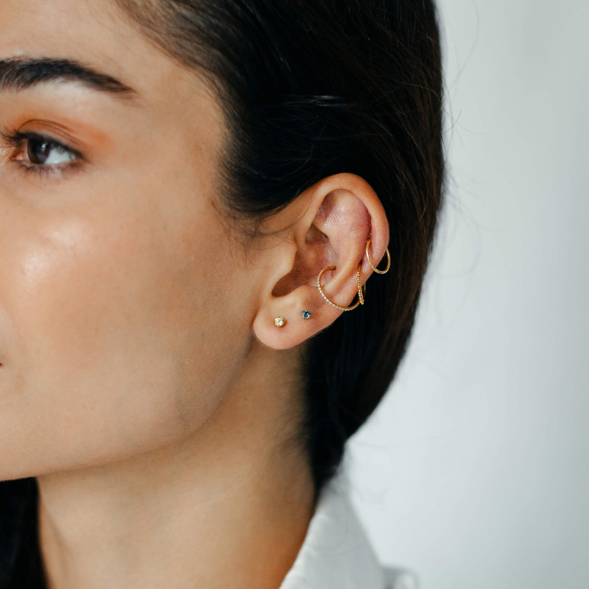 Classic, Siren and Eternity Cartilage Hoop and Moissanite, 3mm and Blue Topaz Nap Earrings (Gold) on model