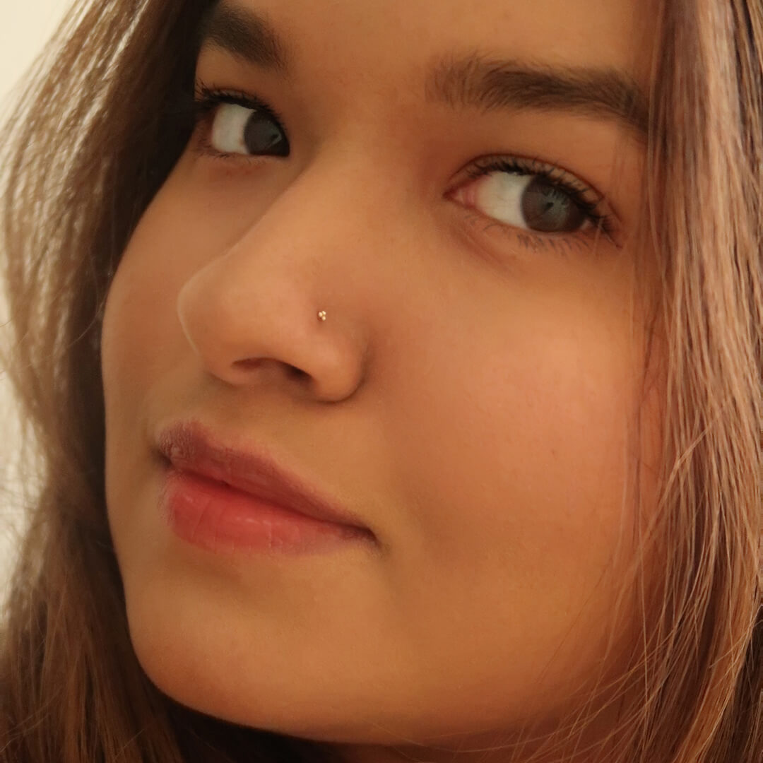 Tiny Trinity Stud L-Shape Nose Ring in 14k Gold on model