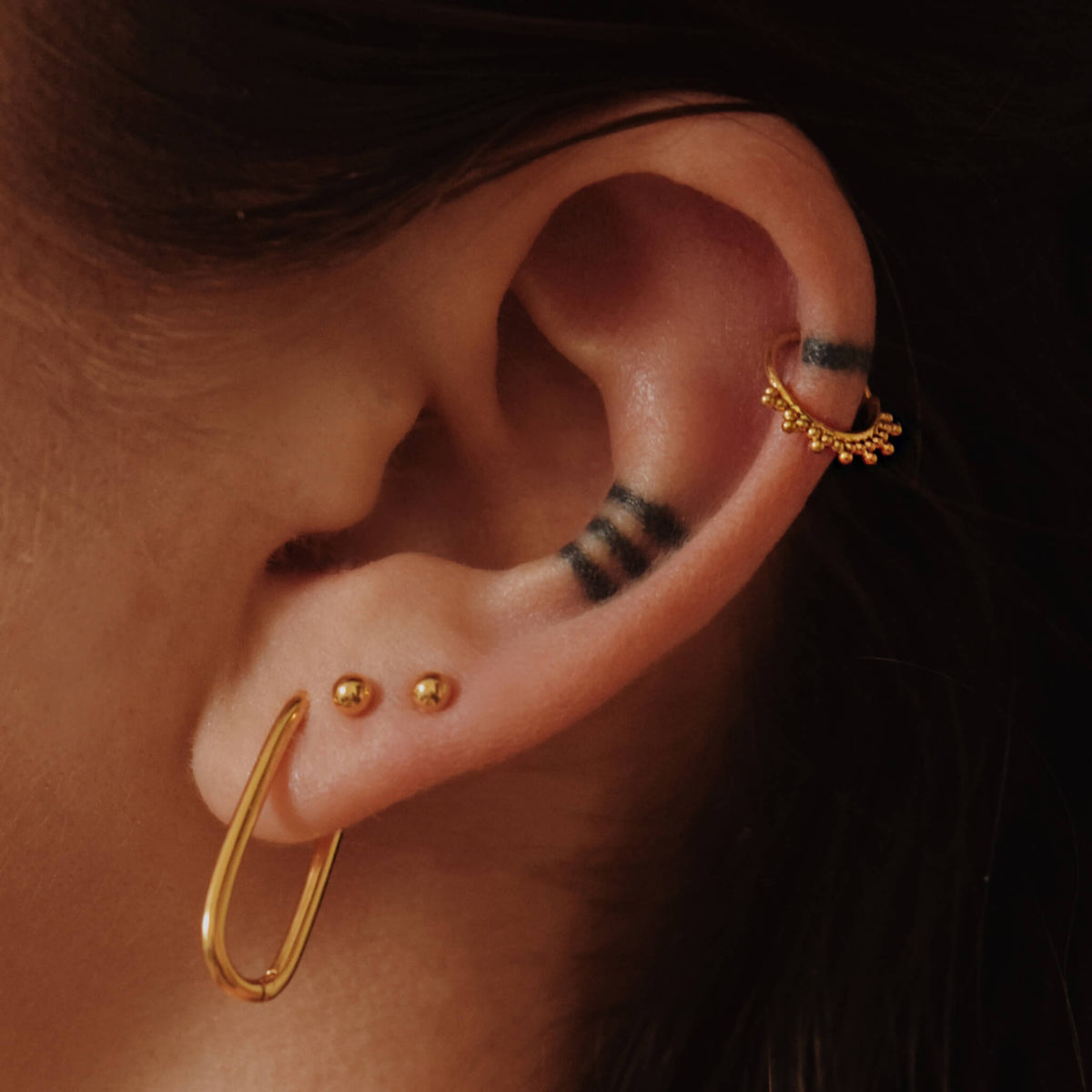 Halo Oval Hoops, 23mm, Sphere Nap Earrings, 3mm and Siren Cartilage Hoop in Gold on model